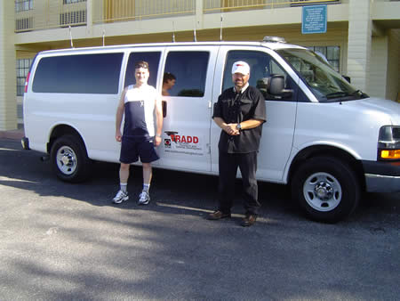 A photo of Bryan Stephens in front of a storm chasing van